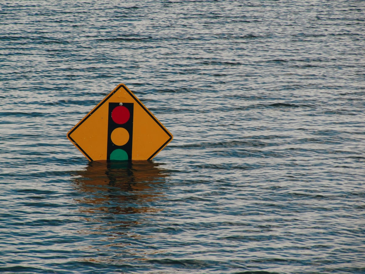 A traffic light sign pokes out of flood water. NS&I's £3 billion IT transformation project has been a disaster say MPs