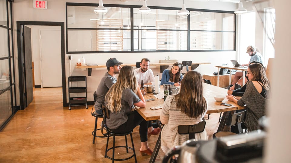 A group of people sat around a desk having a meeting.