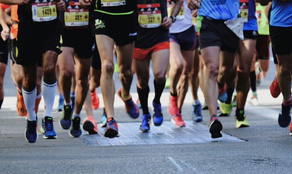 A group of runners in a marathon seen from ground level. Anthropic developed a new harness for long-running coding projects.