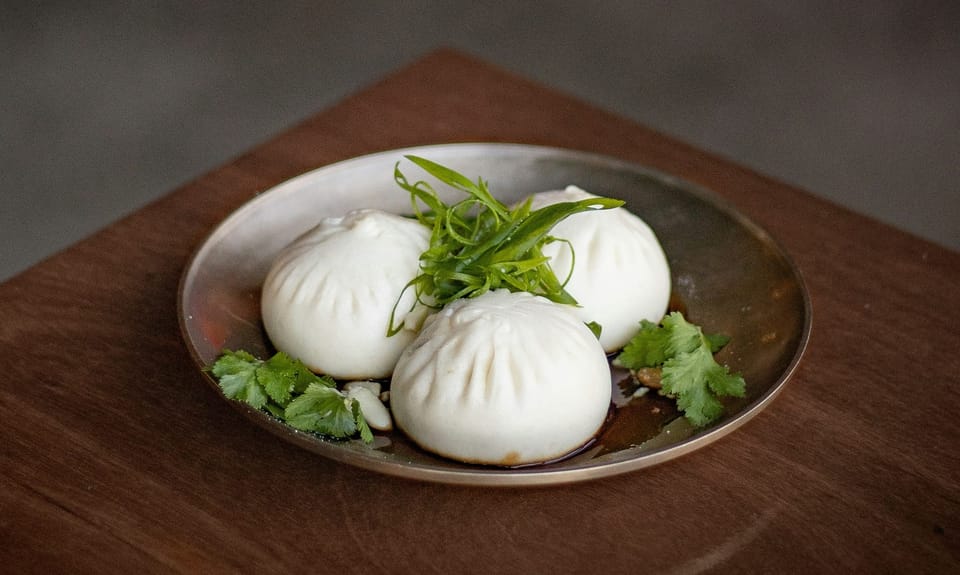 A plate of three bao buns. Anthropic has acquired open source project Bun