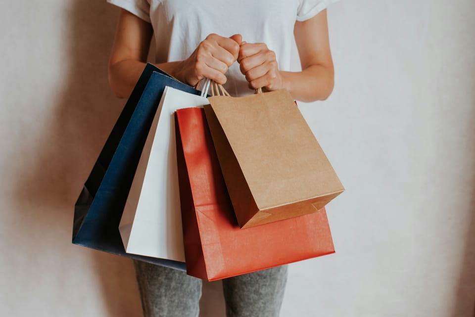 A person holds four shopping bags in their hands. Google launched its Univerisal Commerce Protocol 